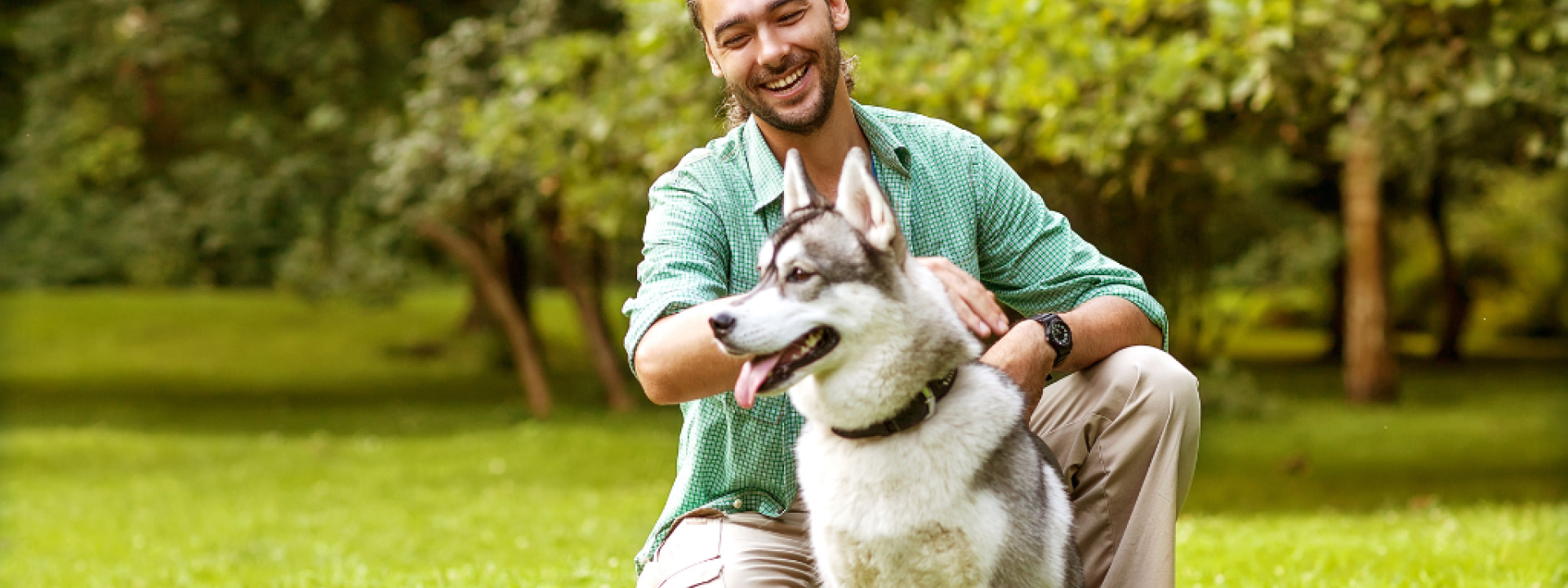 Man and Husky dog walk in the park.